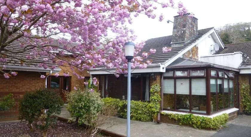 Woodville B&B exterior under pink blossom